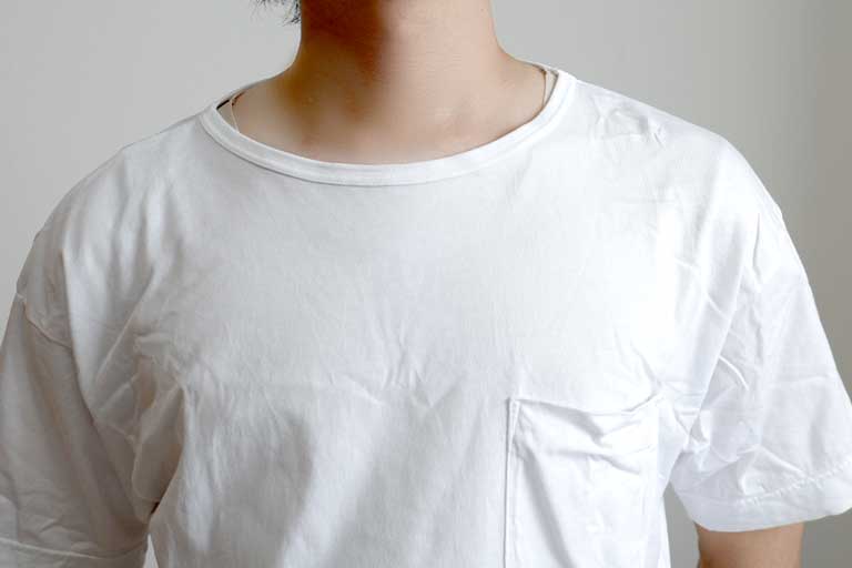 白Tシャツの襟元からインナーのベージュがチラ見えしている画像